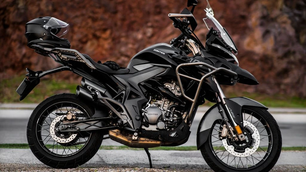 Adventure motorcycle at a mountain pass overlook at dawn